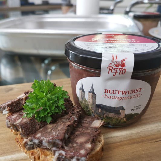 Aufgeschnittenes Brot mit hausgemachter Blutwurst in scheiben, garniert mit frischer Petersilie, daneben die Glaskonserve