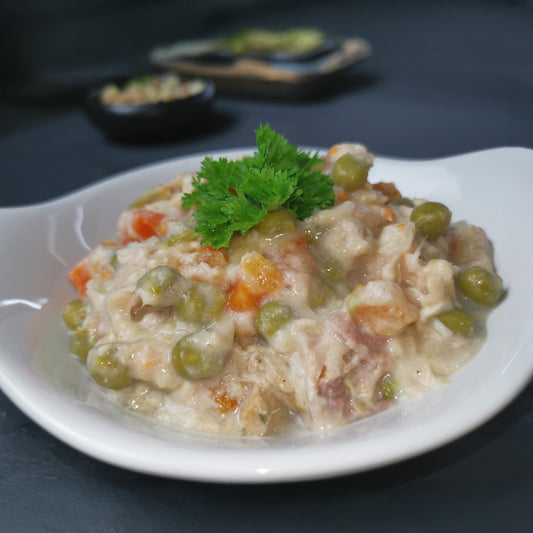 hausgemachtes Hühnerfrikassee auf einem Teller, angerichtet mit Petersilie als Serviervorschlag