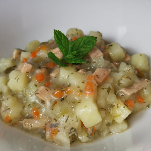 hausgemachte Kartoffelstücke Süß-Sauer auf einem Teller, angerichtet mit frischer Minze als Serviervorschlag
