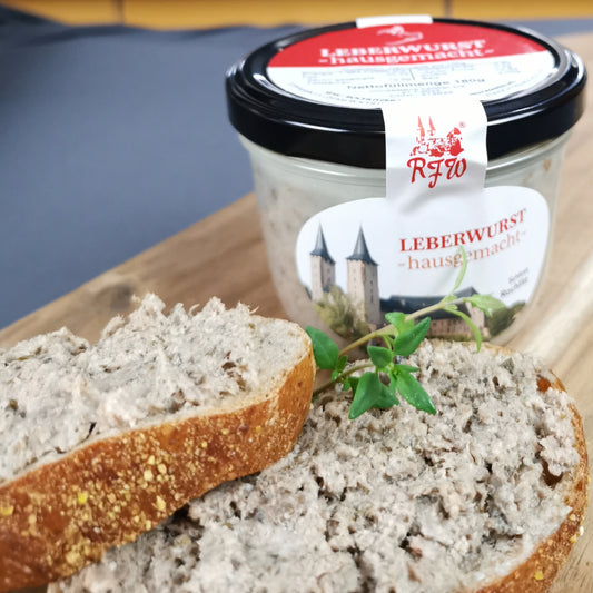 Aufgeschnittenes Brot mit hausgemachter Leberwurst, garniert mit frischer Petersilie, neben der Glaskonserve