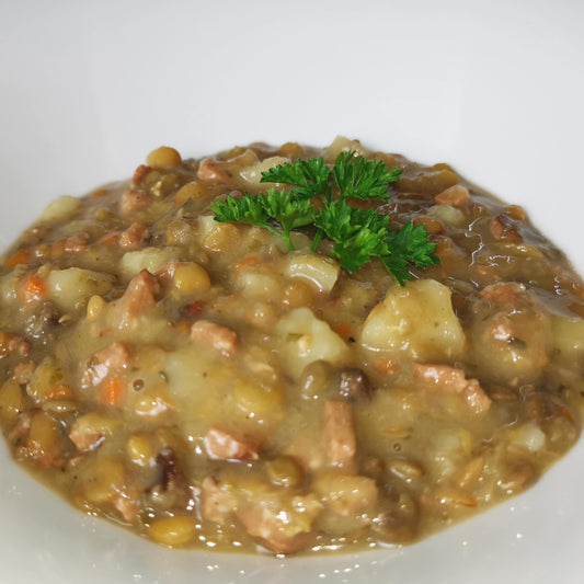 hausgemachter Linseneintopf auf einem Teller, angerichtet als Serviervorschlag garniert mit frischer Petersilie