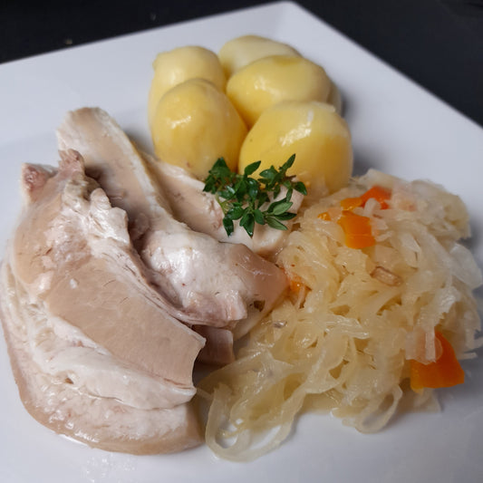 Wellfleisch mit Kartoffeln und Sauerkraut auf einem Teller, angerichtet als Serviervorschlag